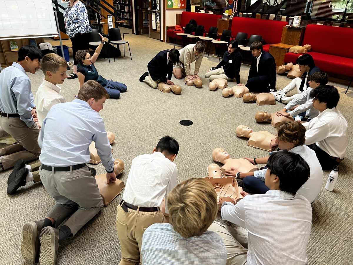 Eaglebrook students practice CPR chest compressions on life models in the Copley Library.