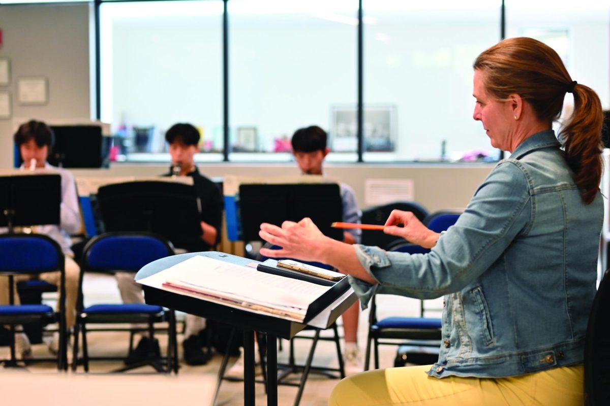 Ms. Melnik leads a practice session as the school orchestra prepares for its first concert at Country Fair.